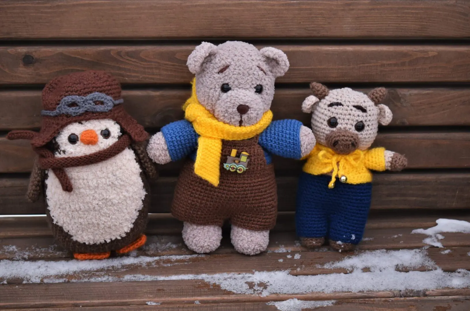 A group of stuffed animals sitting on top of a bench.